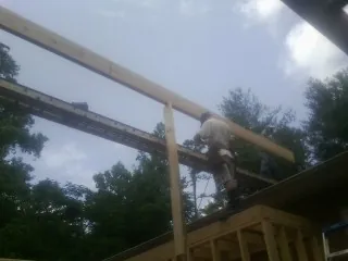 Carpenter setting a ridge beam over a new addition frame — Ice Dam Removal by Roofing Brothers in Botkins