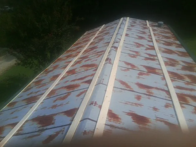 Rusted metal roof panels with new wood purlins before replacement — Storm Damage Roof Repair in Botkins by Roofing Brothers